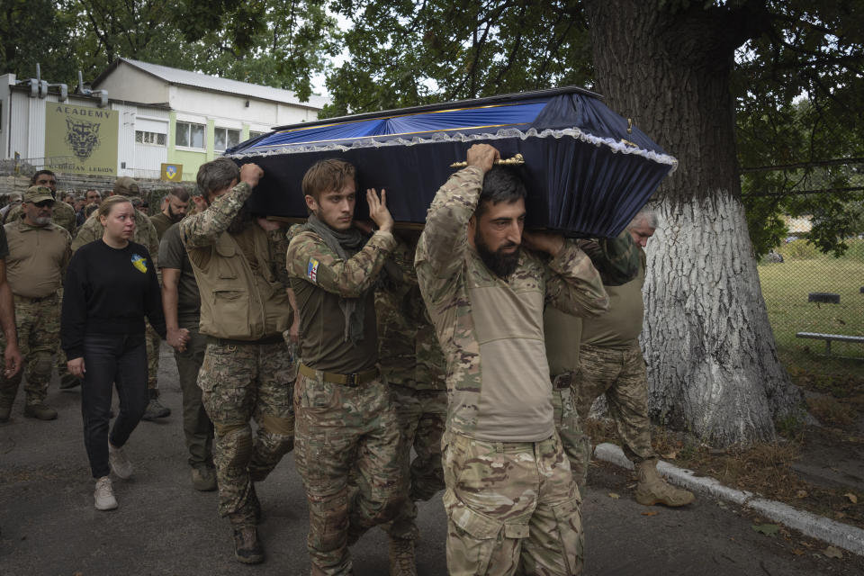 Volunteers of the Georgian legion carry a coffin of their comrade Zakaria Shubitidze, who was killed in a battle with the Russian troops, during a funeral ceremony in Kyiv, Ukraine, Thursday, Sept. 21, 2023. The Georgian legion is a military unit formed mainly by ethnic Georgian volunteers. (AP Photo/Efrem Lukatsky)