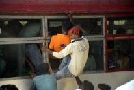 GHAZIABAD, INDIA - MARCH 28: Migrant workers try to board an overcrowded bus bound to their native state on Day 4 of the 21 day nationwide lockdown -- to check the spread of coronavirus, at Lal Kuan bus stand, on March 28, 2020 in Ghaziabad, India. (Photo by Sakib Ali/Hindustan Times via Getty Images)