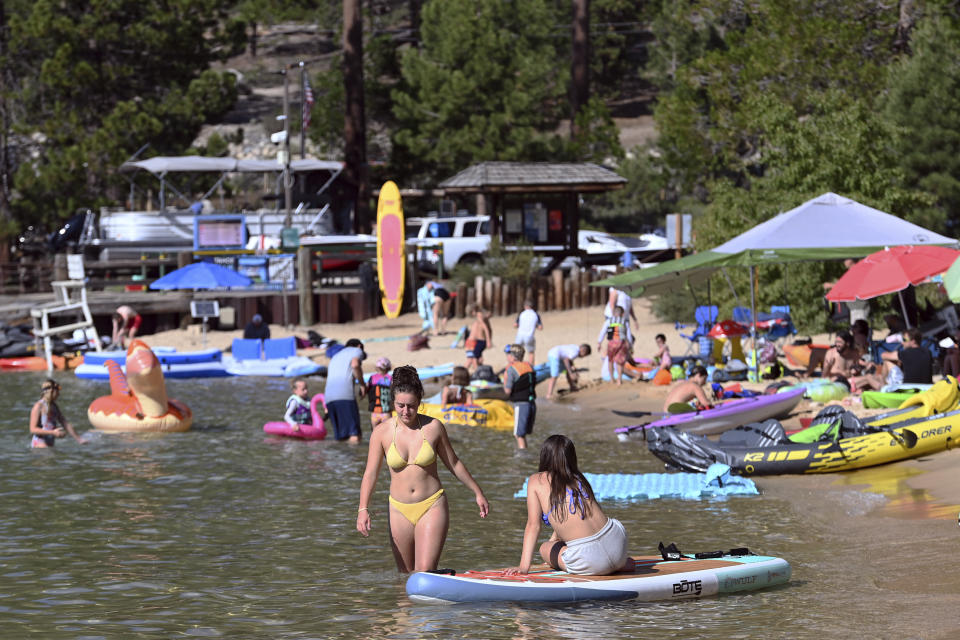 Visitors to Lake Tahoe fill a section of Sand Harbor at Lake Tahoe Nevada State Park in Incline Village, Nev., Monday, July 17, 2023. Tourism officials at Lake Tahoe were surprised, and a bit standoffish, when a respected international travel guide included the iconic alpine lake straddling the California line on a list of places to stay away from this year because of the harmful ecological effects of “over-tourism.” (AP Photo/Andy Barron)