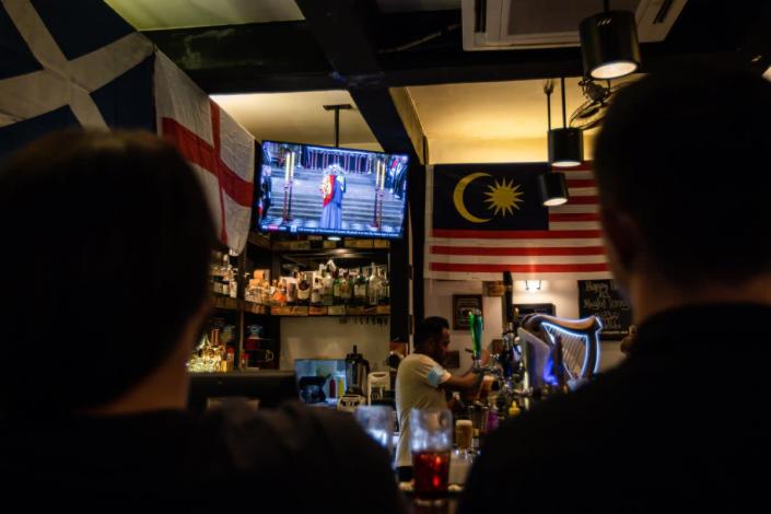 Customers watch the funeral at a British pub in Kuala Lumpur (Getty Images)