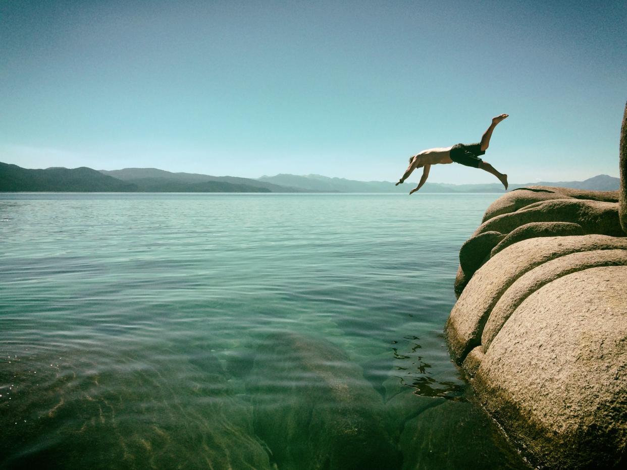 Man diving off rocks into Lake Tahoe