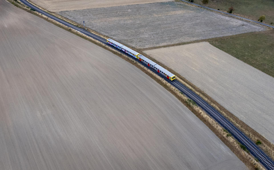 A regional train passes fields near Wehrheim, Germany, Thursday, Sept. 1, 2022, the day after the government's 9-euro-ticket offer ended. (AP Photo/Michael Probst)