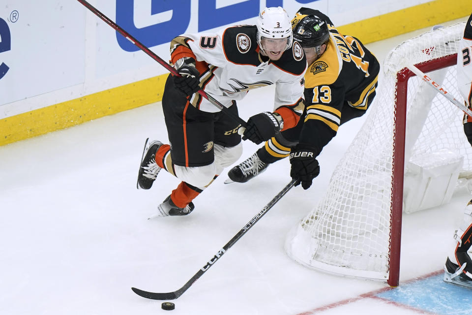 Anaheim Ducks defenseman John Klingberg (3) and Boston Bruins center Charlie Coyle (13) vie for control of the puck during the second period of an NHL hockey game Thursday, Oct. 20, 2022, in Boston. (AP Photo//Steven Senne)