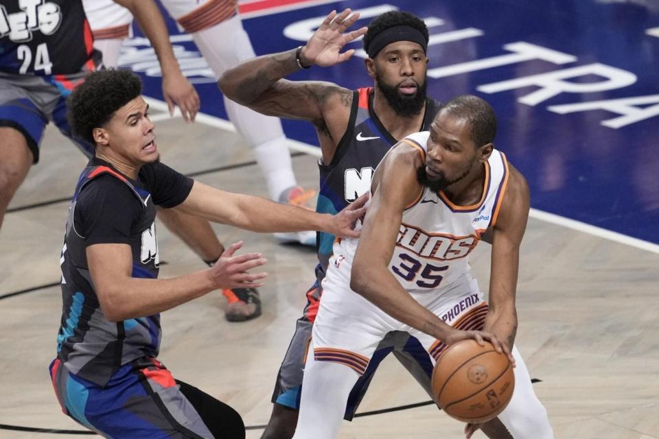 Brooklyn Nets forward Cameron Johnson, left, and forward Royce O'Neale guard Phoenix Suns forward Kevin Durant (35) during the first half of an NBA basketball game, Wednesday, Jan. 31, 2024, in New York.