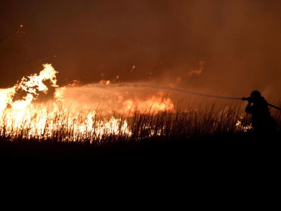 A firefighter works to control the Rhea Fire near Seiling, Oklahoma (REUTERS/Nick Oxford)