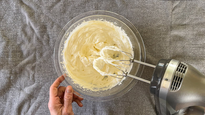 Cream whipped to soft peaks with hand mixer in mixing bowl