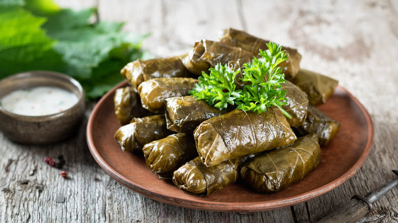 Canned dolmas on plate with creamy dip 