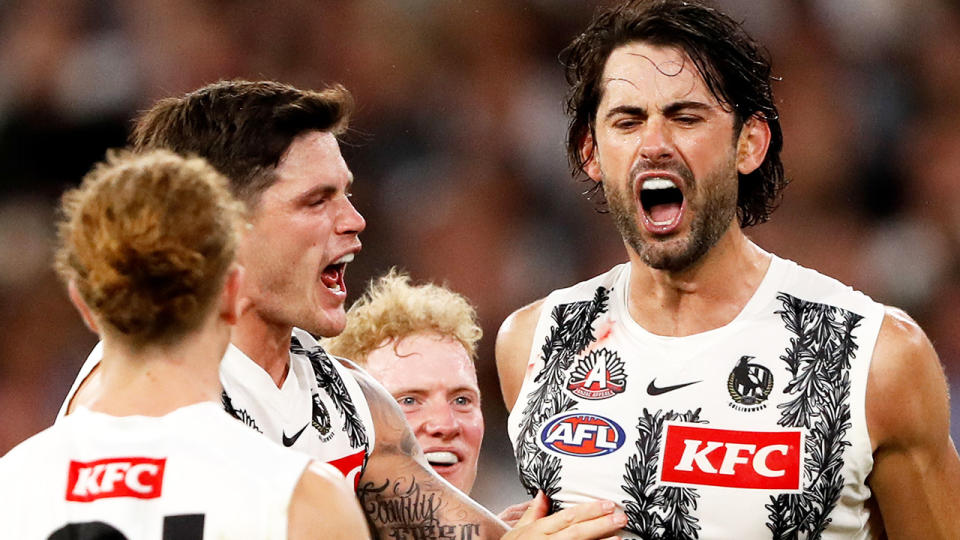 Brodie Grundy is pictured celebrating a goal with Collingwood teammates.
