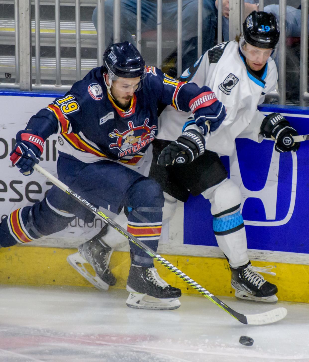 Peoria's Zach Wilkie, left, and Quad City's Taylor Pryce battle for the puck along the boards in the first period Friday, Jan. 21, 2022 at Carver Arena. The Rivermen defeated the Quad City Storm 3-2 in sudden-death overtime.