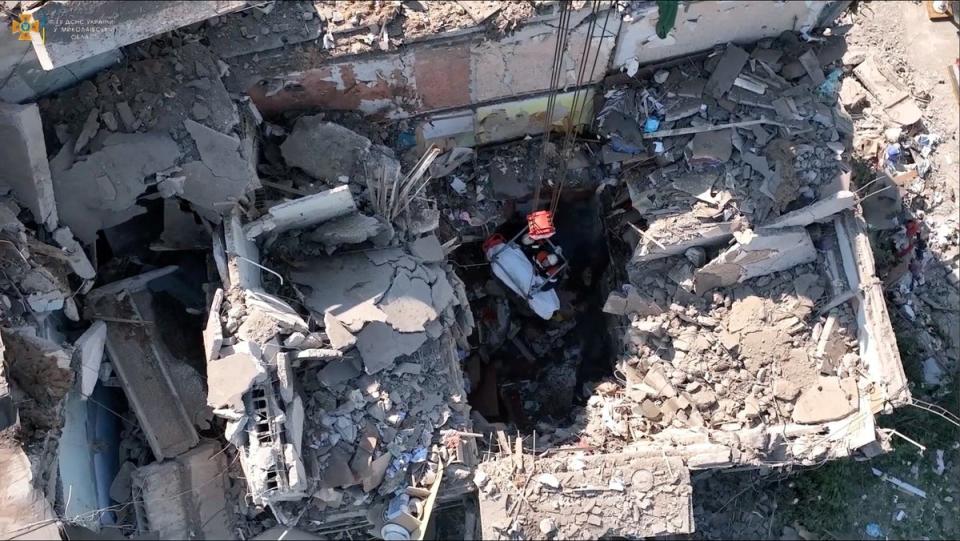 Rescue workers pull out a body from a residential building hit by a Russian military strike (via REUTERS)