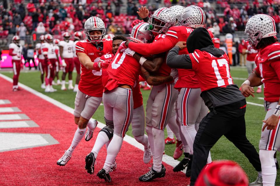 Teammates mob Ohio State wide receiver Kamryn Babb (0) after the first touchdown of his collegiate career.