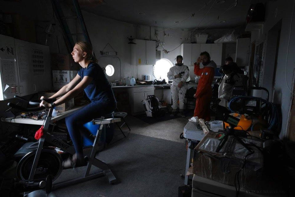 Anastasiya Stepanova exercises while fellow Mars 160 crewmembers prepare for an extravehicular activity. <cite>The Mars Society</cite>