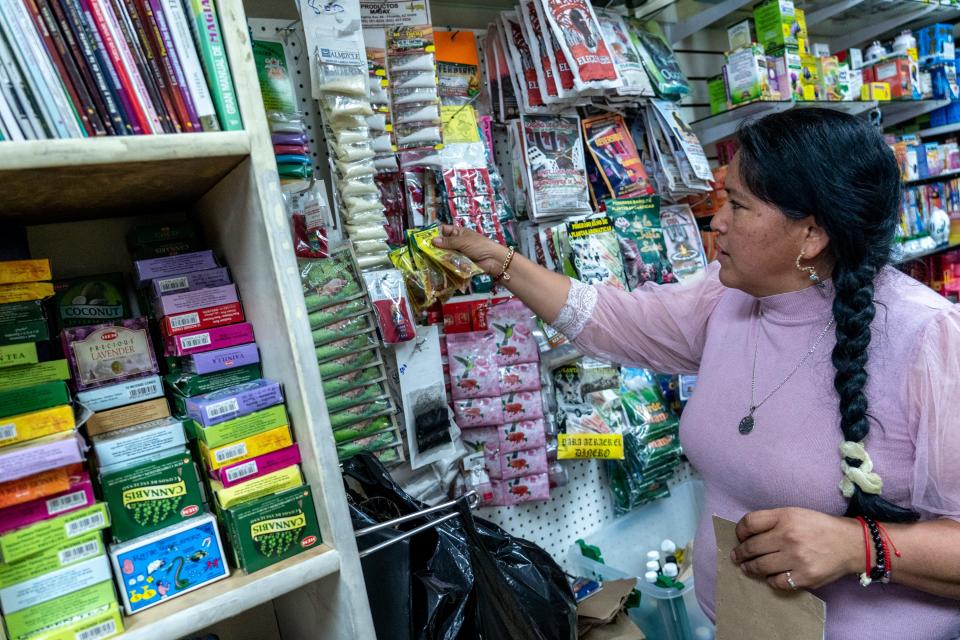 Gabriela Lozano of Yerberia El Cuerno de la Abundancia browses the inside of her shop in Glendale on June 9, 2023.