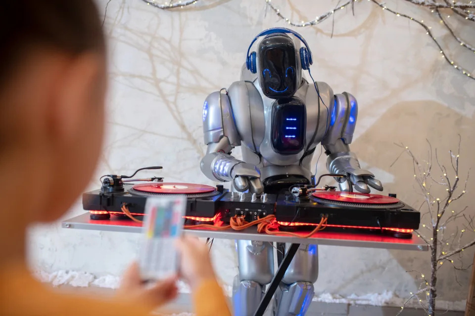 Robot dj. Girl making a selfie of her digital friend standing near dj table