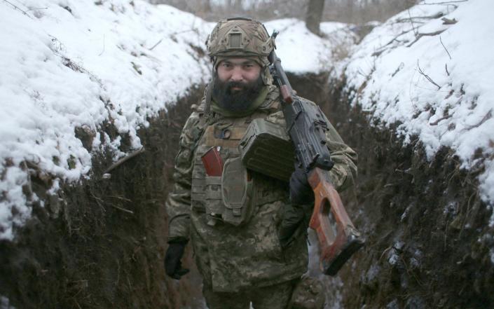 An Ukrainian Military Forces serviceman poses with his weapons in a trench on the frontline with the Russia-backed separatists near Zolote village, in the eastern Lugansk region, on January 21 - Anatolii Stepanov/AFP