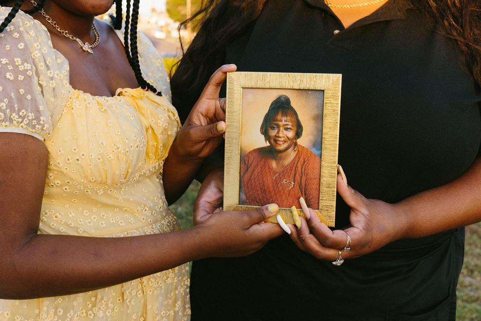 Ashley Manning and daughter Rhiley hold a photograph of Ashley’s grandma who died of COVID-19.