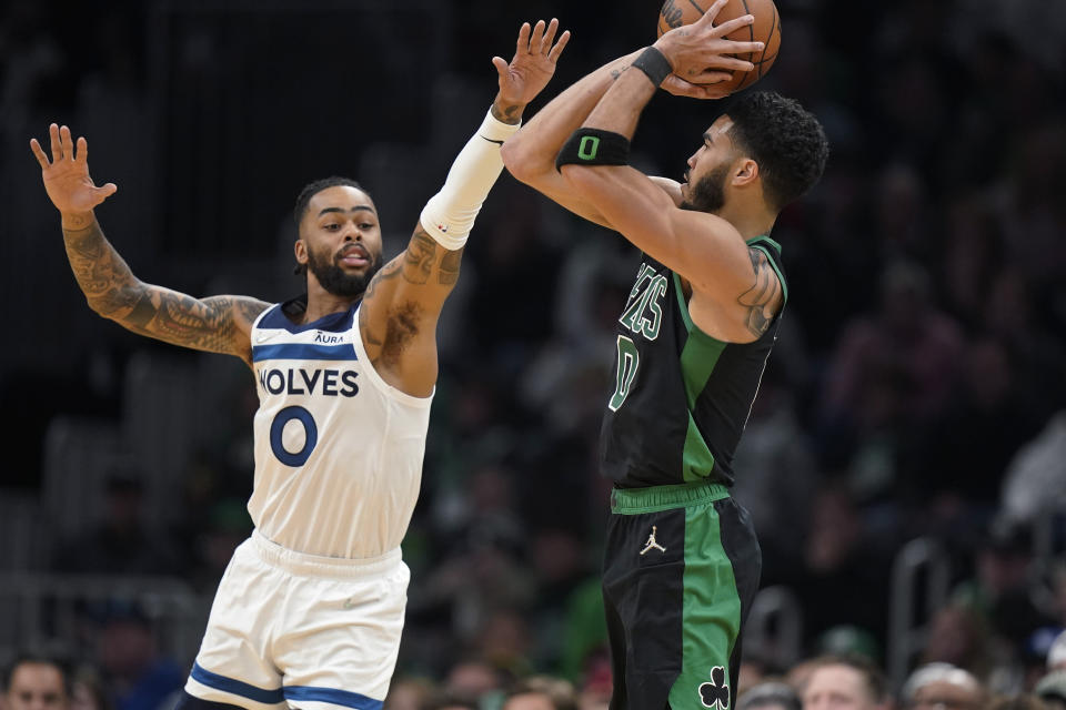 Minnesota Timberwolves guard D'Angelo Russell (0) tries to block Boston Celtics forward Jayson Tatum (0) who takes a shot at the basket in the second half of an NBA basketball game, Sunday, March 27, 2022, in Boston. The Celtics won 134-112. (AP Photo/Steven Senne)