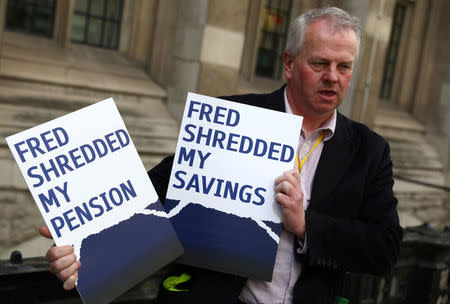 A man holds placards outside of the Royal Courts as Bank of Scotland (RBS) pursued last-minute settlement talks with a group of investors to avoid a potentially embarrassing trial over allegations the lender misled them about a 2008 capital increase, in London in London, Britain May 22, 2017. REUTERS/Neil Hall