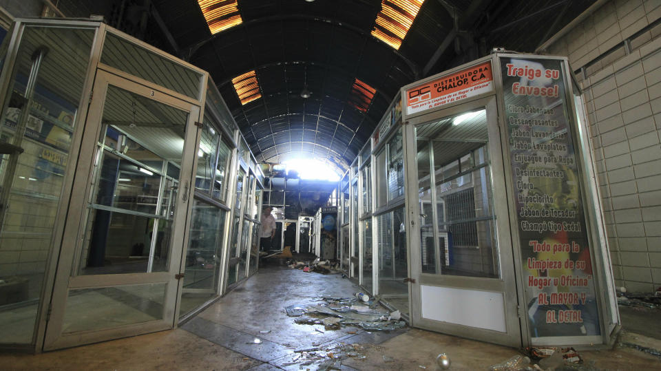 The hallway of a mall is trashed after stores stand empty one day after it was looted in Maracaibo, Venezuela, Wednesday, March 13, 2019. Venezuela's largest private food supplier says massive looting and vandalism occurred at four facilities in the city of Maracaibo during nationwide power outages, complicating efforts to distribute food and drinks to people in the area. (AP Photo/Henry Chirinos)