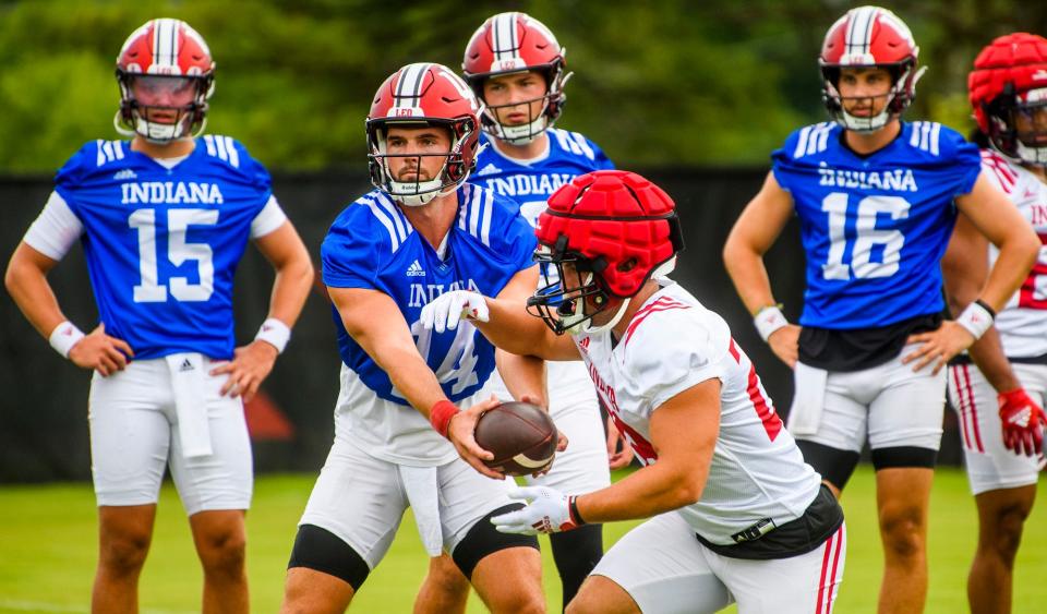 Indiana's Jack Tuttle (14) makes the hand-off during the first open practice of the 2022 season at the practice facility at Indiana University on Tuesday, August 2, 2022.