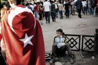A young Turkish protester rests as others demonstrate, on June 6, 2013, at Kizilay Square, in Ankara