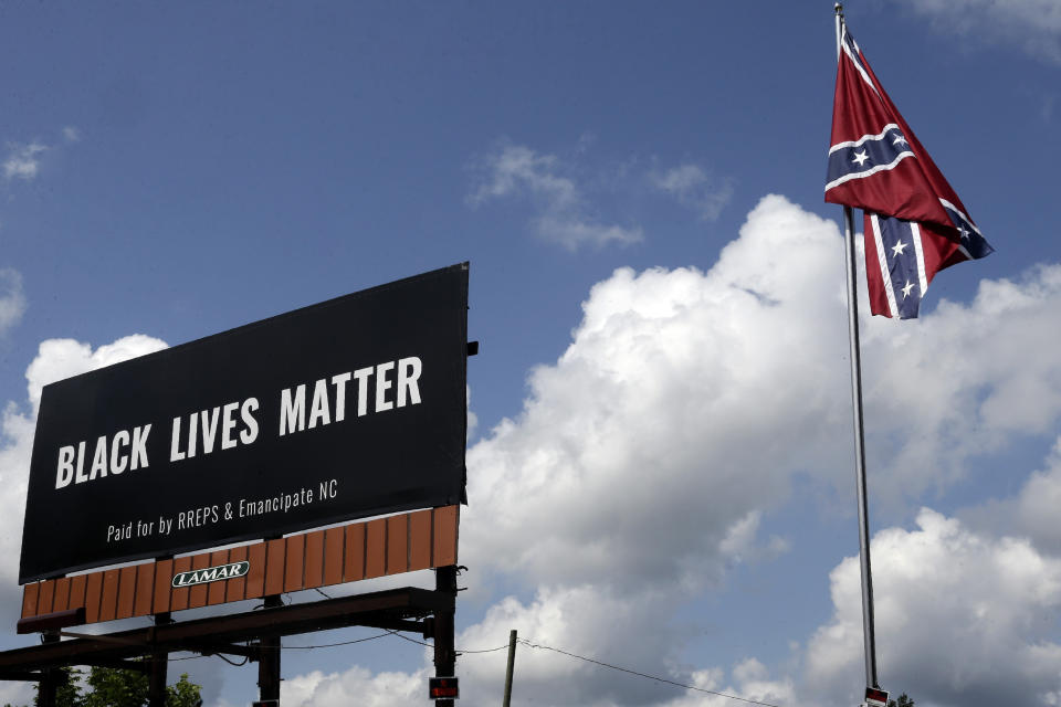 A Black Lives Matter billboard is seen next to a Confederate flag in Pittsboro, N.C., Thursday, July 16, 2020. A group in North Carolina erected the billboard to counter the flag that stands along the road. (AP Photo/Gerry Broome)