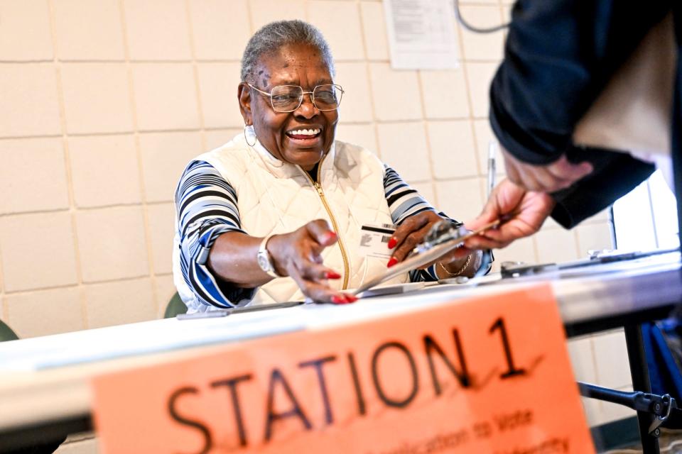 Poll worker Mary Jackson helps a Michigan primary voter at the new polling place at Potter Park Zoo on Tuesday, Feb. 27, 2024, in Lansing.