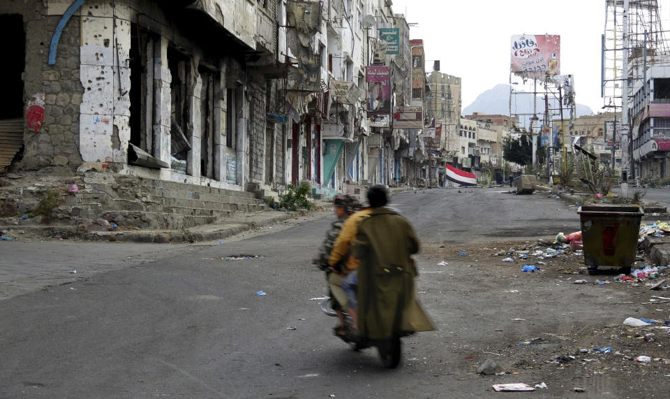 FILE - Men ride through streets wrecked by fighting in Taiz, Yemen, Feb. 4, 2018. In a joint statement Monday, Aug. 29, 2022, sixteen rights groups urged Yemen’s Houthi rebels to end their years-long siege of Taiz, the country’s third-largest city. The groups, including Human Rights Watch and Amnesty International, said in a joint statement the Houthi blockade of Taiz has severely restricted freedom of movement and impeded the flow of essential goods, medicine, and humanitarian aid to the city’s residents. (AP Photo, File)