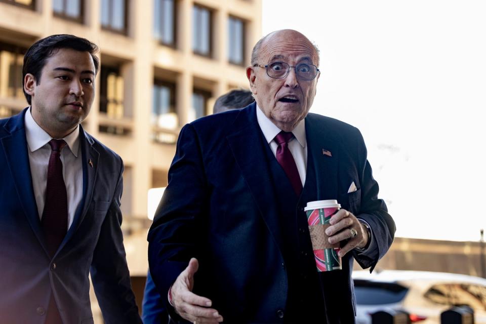Rudy Giuliani arrives at US District Court in Washington DC on 15 December, the day an eight-member jury ruled he must pay a pair of election workers nearly $150m for his lies about them (EPA)