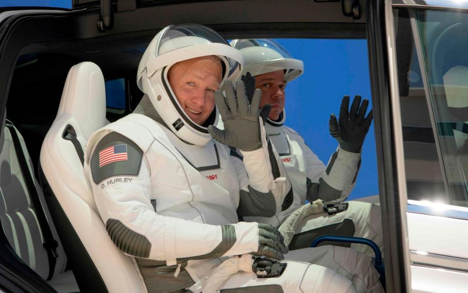 NASA astronauts Douglas Hurley, left, and Robert Behnken, wearing SpaceX spacesuits, are seen as they depart the Neil A. Armstrong Operations and Checkout Building for Launch Complex 39A - NASA/NASA