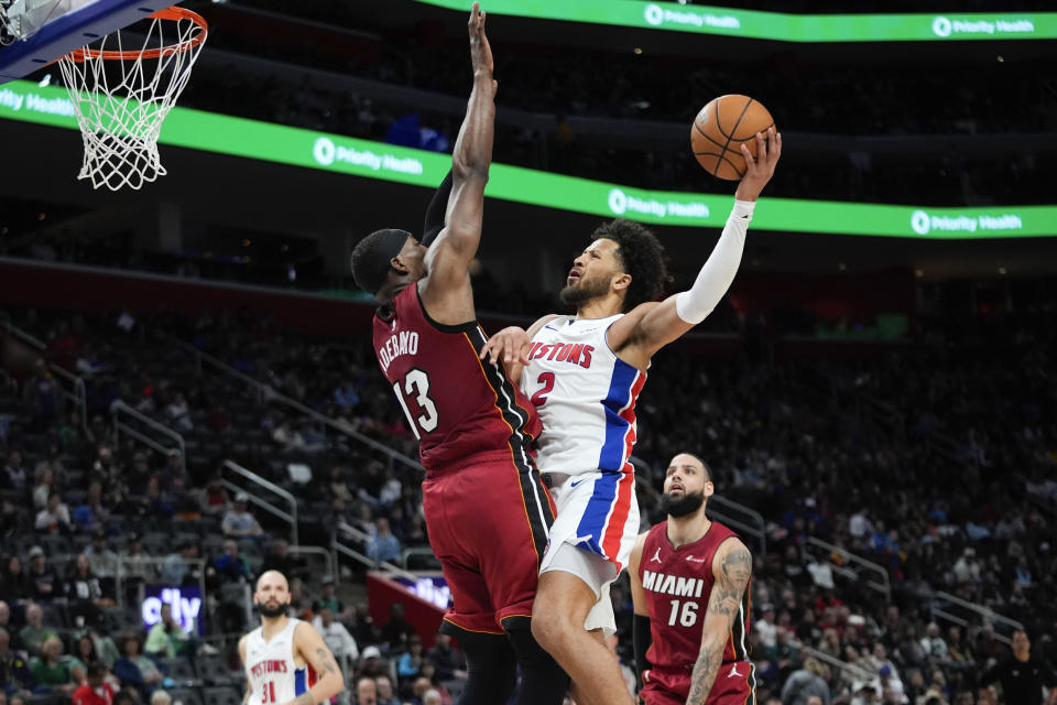 Detroit Pistons guard Cade Cunningham (2) drives on Miami Heat center Bam Adebayo (13) in the first half of an NBA basketball game in Detroit, Sunday, March 17, 2024. (AP Photo/Paul Sancya)