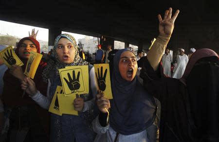 Members of the Muslim Brotherhood and supporters of ousted Egyptian President Mohamed Mursi shout slogans against the military and interior ministry, as they show the "Rabaa" or "four" gesture, in reference to the police clearing of Rabaa al-Adawiya protest camp on August 14, during a protest and rally named "The coup is terrorism" in the southern suburb of Maadi September 3, 2013. REUTERS/Amr Abdallah Dalsh