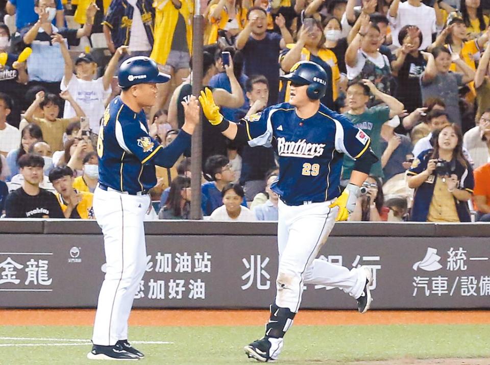 中信兄弟象野手陳俊秀（右）6局上敲出3分炮，跑壘時和三壘指導教練擊掌慶祝。（趙雙傑攝）