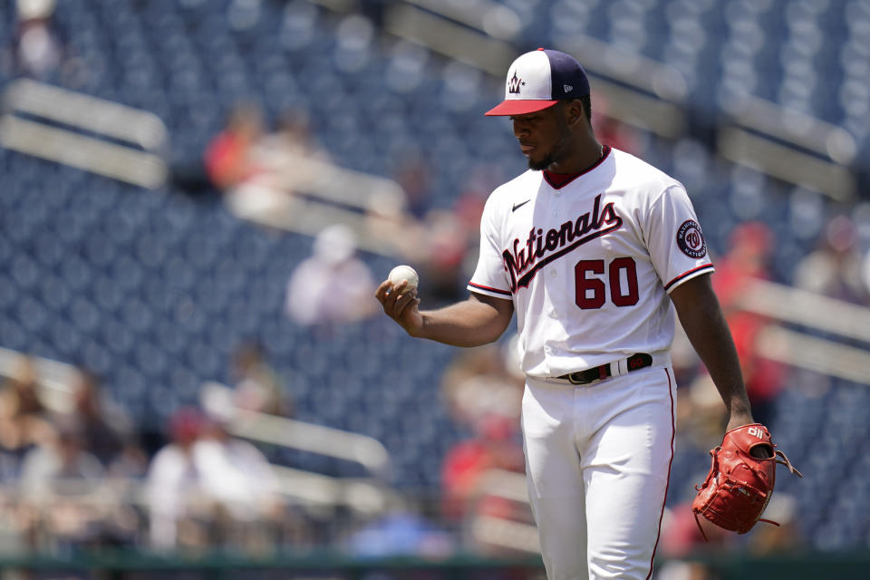 Washington Nationals starting pitcher Joan Adon pauses after Philadelphia Phillies' Nick Castellanos scored on Alec Bohm's double in the third inning of the first game of a baseball doubleheader, Friday, June 17, 2022, in Washington. (AP Photo/Patrick Semansky)