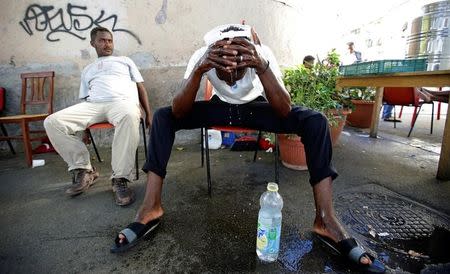 A migrant washes himself at a makeshift camp in Via Cupa (Gloomy Street) in downtown Rome, Italy, August 1, 2016. REUTERS/Max Rossi