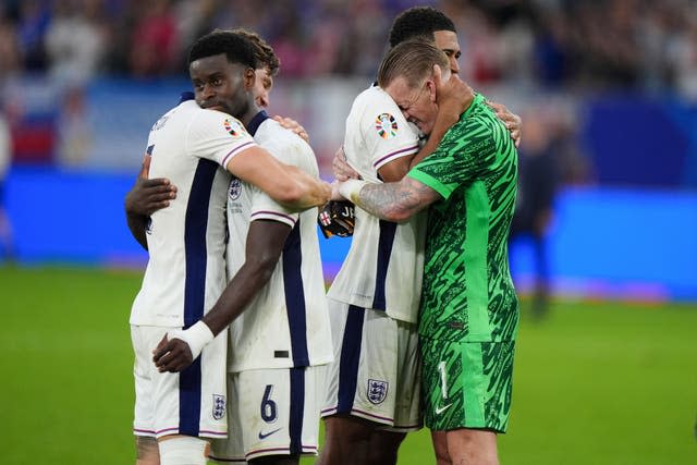 John Stones hugs Marc Guehi and Jude Bellingham embraces Jordan Pickford