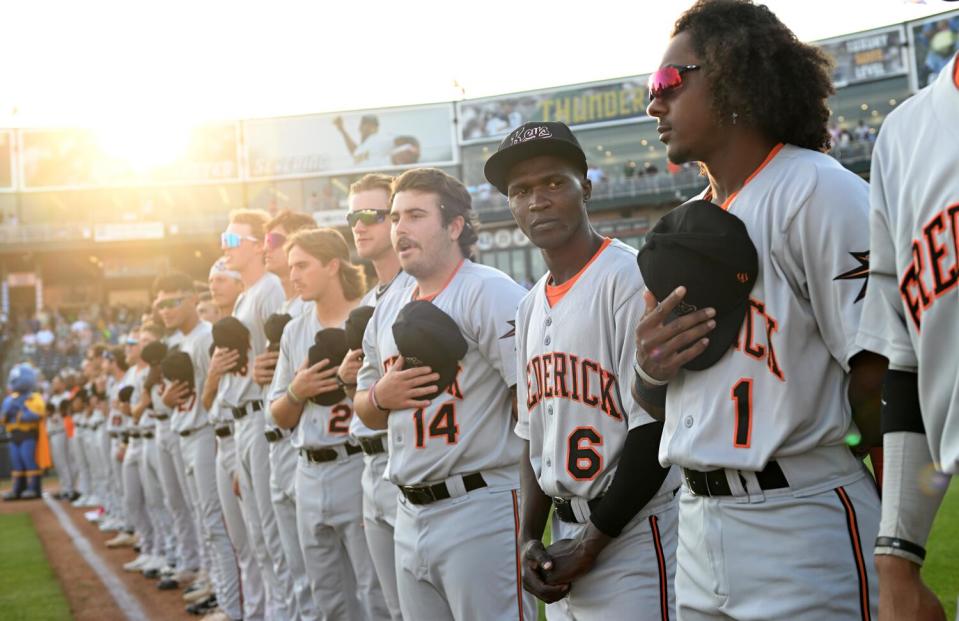 Not understanding the etiquette of the national anthem, Frederick Keys player Dennis Kasumba looks to teammates for guidance.