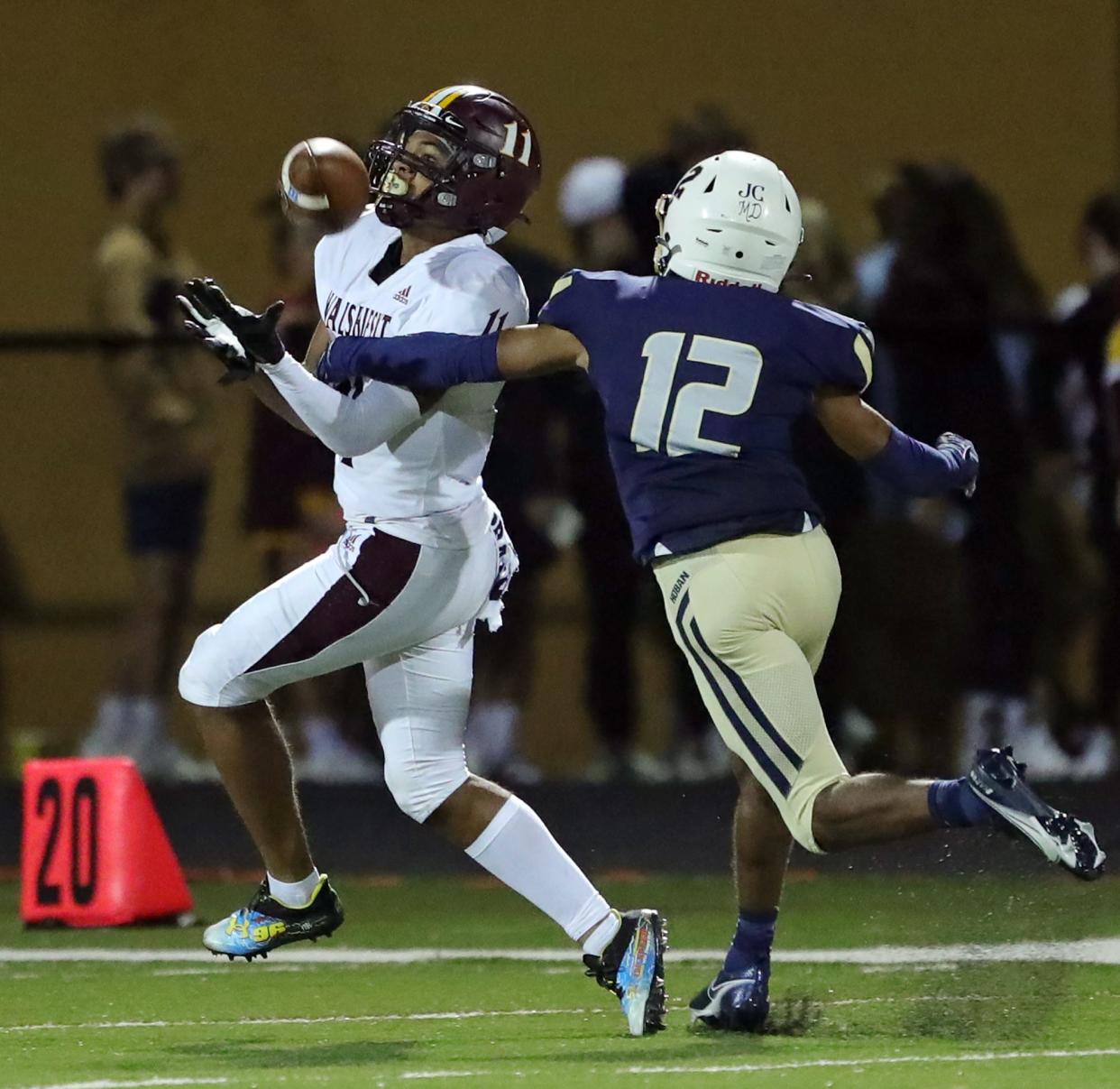 Walsh Jesuit wide receiver Trey Bell, left, eyes down a pass against Hoban defensive back Davion Jennings during the second half of a high school football game, Friday, Sept. 3, 2021, in Akron, Ohio.