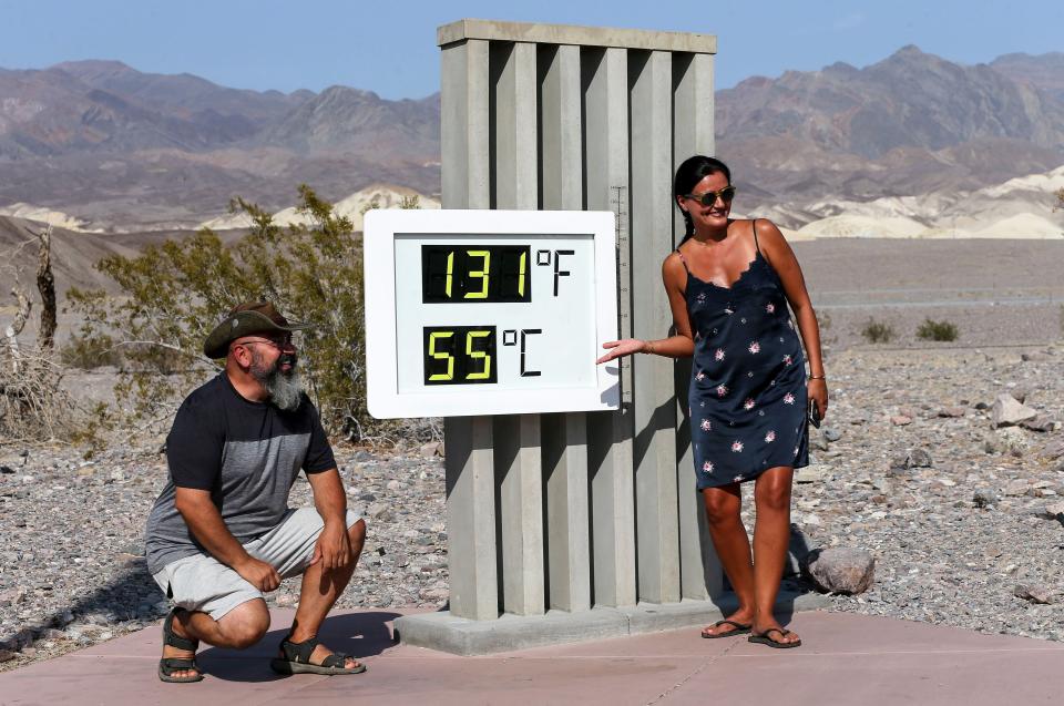 DEATH VALLEY NATIONAL PARK, CALIFORNIA - AUGUST 17: Visitors gather for a photo in front of an unofficial thermometer at Furnace Creek Visitor Center on August 17, 2020 in Death Valley National Park, California. The temperature reached 130 degrees at Death Valley National Park on August 16, hitting what may be the hottest temperature recorded on Earth since at least 1913, according to the National Weather Service. Park visitors have been warned, ‘Travel prepared to survive.’ (Photo by Mario Tama/Getty Images)