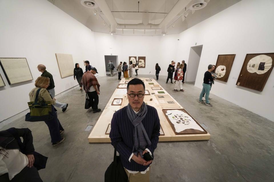 Korean artist King Suen Lee stands next to his installation "Untitled (constellation)" during the media open day of the 60th Biennale of Arts exhibition in Venice, Italy, Tuesday, April 16, 2024. The Venice Biennale contemporary art exhibition opens Saturday for its six-month run through Nov. 26. (AP Photo/Luca Bruno)