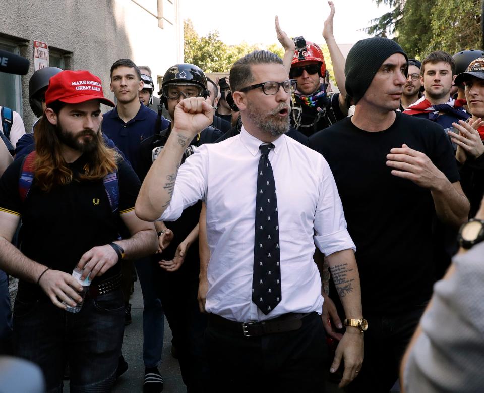 In this April 27, 2017 file photo, Gavin McInnes, center, founder of the far-right group Proud Boys, is surrounded by supporters after speaking at a rally in Berkeley, Calif. McInnes and his Proud Boys group have been banned from Facebook and Instagram because of policies prohibiting hate groups.