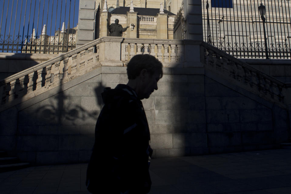 A tourist walks in front of the Almudena cathedral in Madrid, Spain, Thursday, Oct. 25, 2018. Hundreds of protesters in Madrid are urging government and Catholic church authorities to prevent the remains of the country’s 20th century dictator from ending in the city’s cathedral. Spain’s center-left government has promised to exhume this year Gen. Francisco Franco from a glorifying mausoleum, but the late dictator’s heirs have defied the plans by proposing for his remains to be relocated to a family crypt under the cathedral.(AP Photo/Paul White)