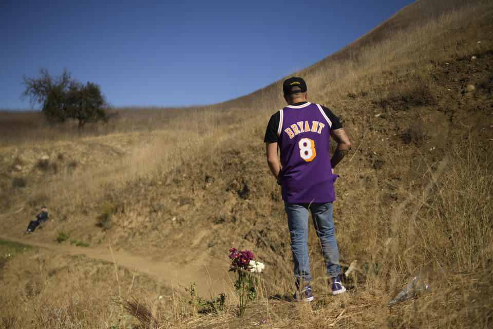 Anthony Calderon leaves flowers to pay his respects at a makeshift memorial on January 26, 2021 in Calabasas, California, at the hillside site of a helicopter crash.