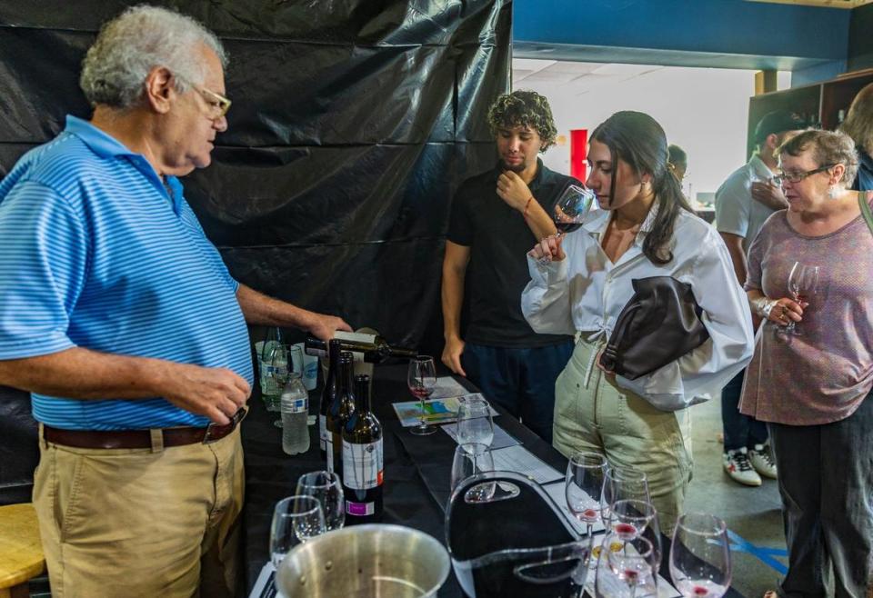 Sunset Corners’ former owner Michael Bittel (far left) serves some wine to Frankie Pons and Karina Asturias (center), during a wine tasting, at the landmark family business Sunset Corners at 8701 Sunset Dr, in Miami, on Saturday, June 1, 2024. Bittel will stay on for the wine tastings as new owner Eddie Cruz takes over the revamped Jensen’s at Sunset Corners.
