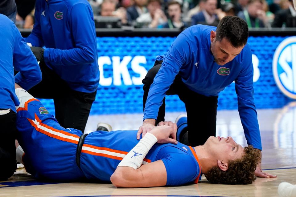 Florida center Micah Handlogten (3) is tended to after an injury during the first half of the SEC tournament championship game against Auburn at Bridgestone Arena in Nashville, Tenn., Sunday, March 17, 2024.