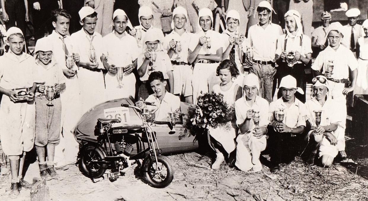 Alice Johnson, 12, holds a bouquet of flowers next to winner Randall Custer, 16, at the first Soap Box Derby on Aug. 19, 1933, in Dayton.