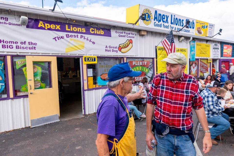 Longtime manager Horace Johnson, left, talks with patron Jonathan Paris of Moore County outside the Apex Lions Club restaurant during the State Fair in Raleigh Monday, Oct. 16, 2023. The Apex Lions Club has been serving food at the fair’s restaurant row since 1943. The restaurant row building will be replaced with an events center next year.