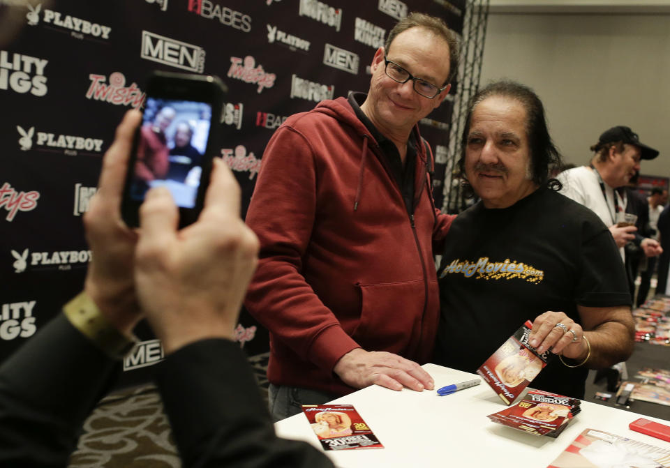 Porn star Ron Jeremy poses for a photo with a fan while signing autographs during the Adult Entertainment Expo, Wednesday, Jan. 15, 2014, in Las Vegas. Potential opportunities for X-rated film production in Nevada were the talk of the Expo at the Hard Rock hotel and casino this week, sparked by a Los Angeles law requiring male actors to wear condoms. (AP Photo/Julie Jacobson)