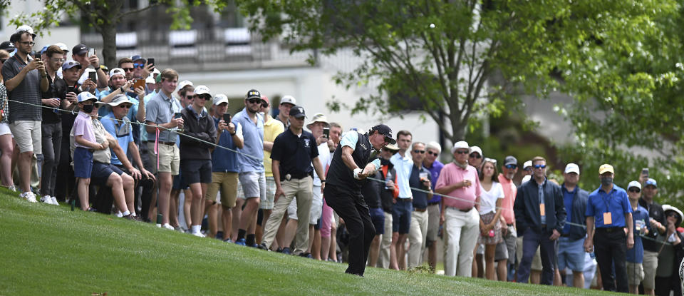 Phil Mickelson hits a shot from a hill near the 15th green during the second round of the Wells Fargo Championship golf tournament at Quail Hollow Club in Charlotte, N.C., Friday, May 7, 2021. (Jeff Siner/The Charlotte Observer via AP)