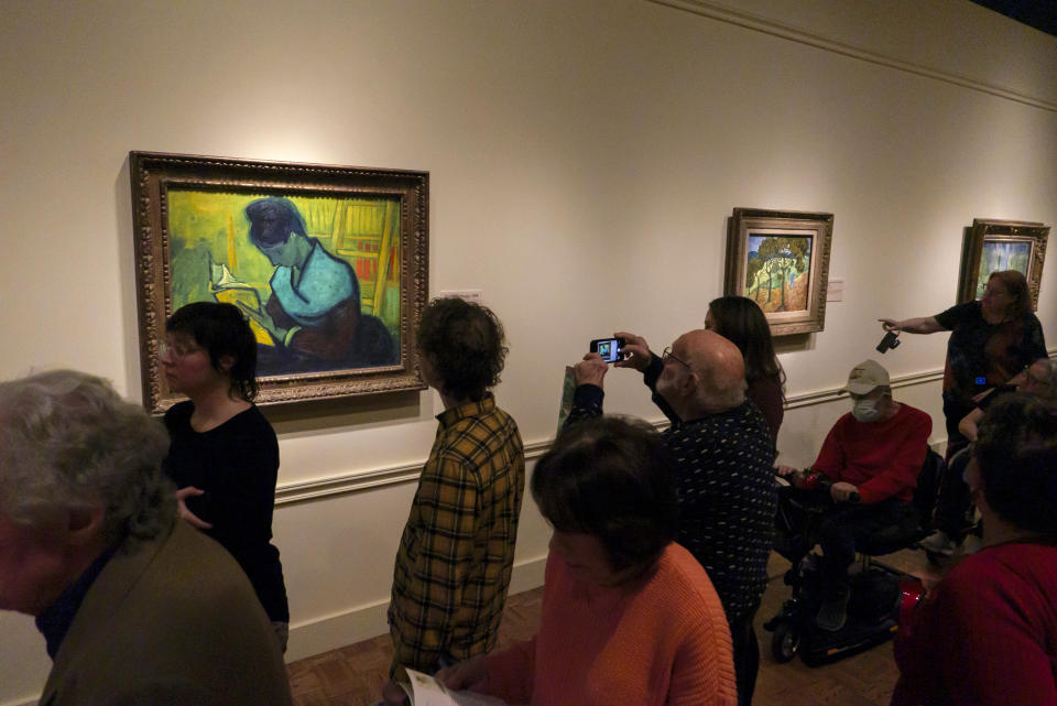 Visitors file past at the Van Gogh painting "Une Liseuse De Romans" — also known as "The Novel Reader", during the Van Gogh in America exhibit at the Detroit Institute of Arts, Wednesday, Jan. 11, 2023, in Detroit. (Andy Morrison/Detroit News via AP)